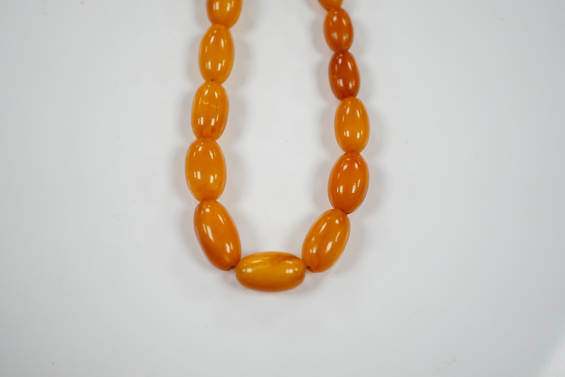 A single strand graduated amber bead necklace, 66cm, gross weight 40 grams. Condition - poor to fair